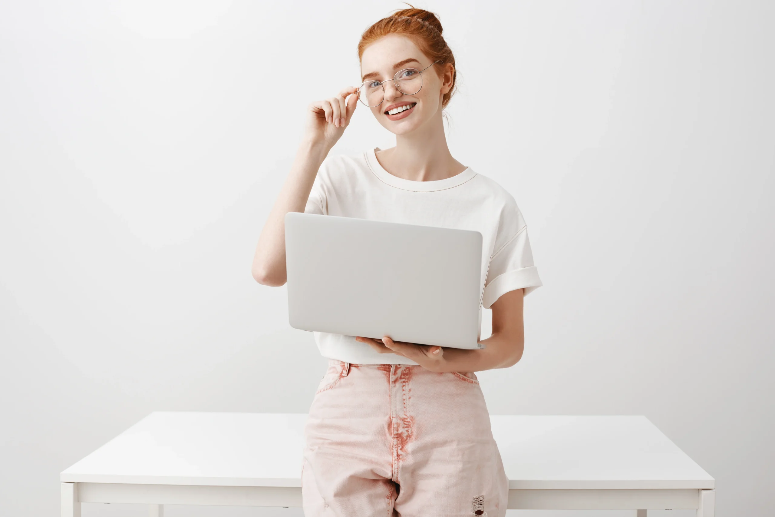 Studentessa sorridente con laptop mentre scrive la tesi triennale
