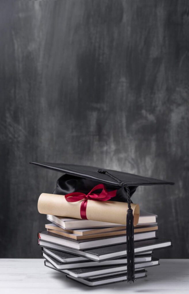 Pila di libri con tocco di laurea e diploma arrotolato con nastro rosso