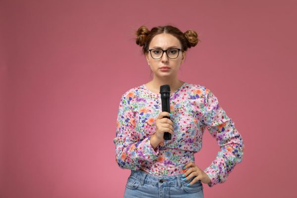 studentessa-ansiosa-discorso-laurea-microfono Studentessa con microfono e sguardo preoccupato: ansia e preparazione del discorso di laurea