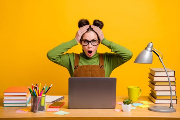 studentessa-scioccata-elaborazione-dati-tesi Studentessa sorpresa davanti al computer con libri e appunti: stress da elaborazione dati per la tesi di laurea